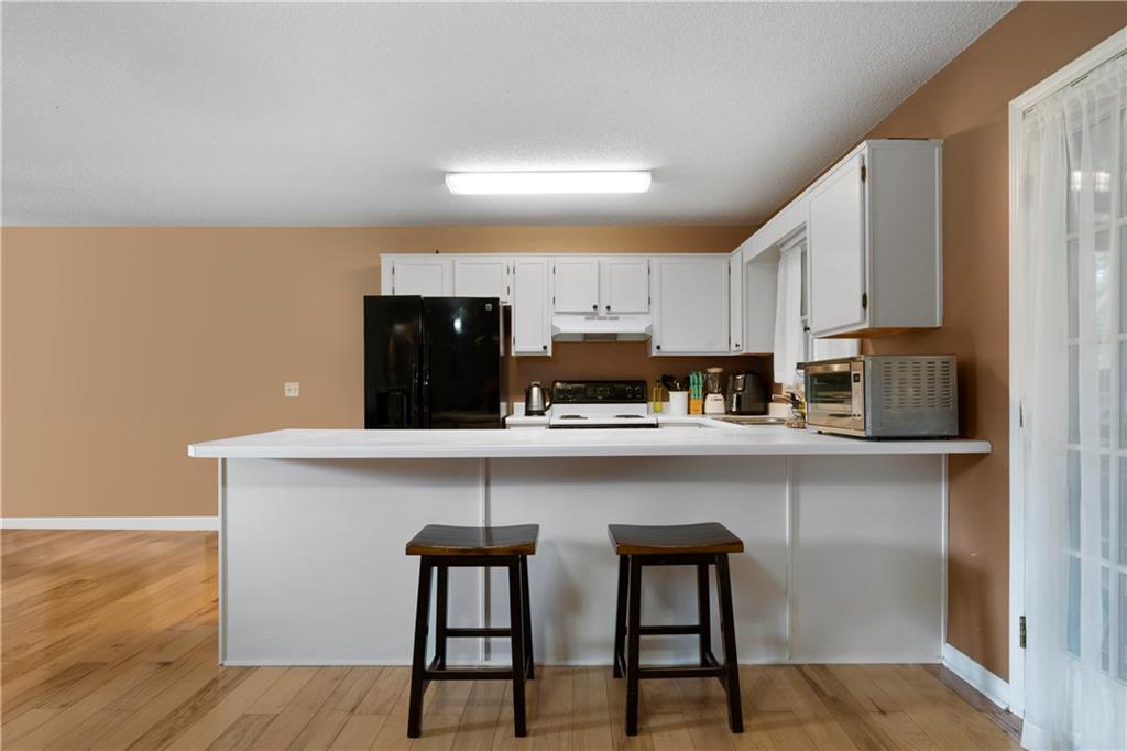 520 Brown Farm Road Southwest Cartersville, GA 30120 - Photo 5 of 16 a kitchen with stainless steel appliances a white table chairs in it and wooden floors