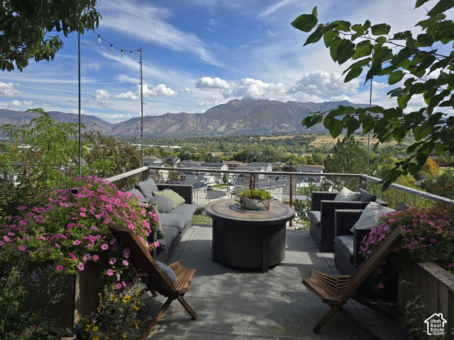 1397 Ritter Drive Riverdale, UT 84405 - Photo 19 of 21 Expansive outdoor deck featuring a mountain backdrop, string lighting, and a glass railing
