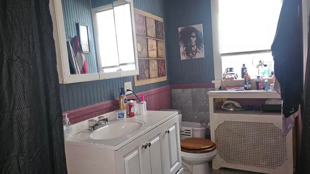 a bathroom with a sink toilet and a mirror