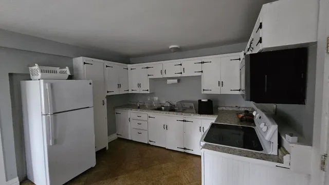 a kitchen with cabinets a refrigerator and a stove