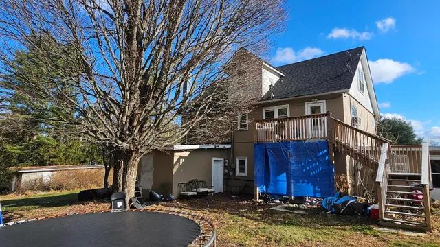 a view of house with yard and car parked