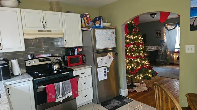 a kitchen with stainless steel appliances kitchen island granite countertop a refrigerator and a stove