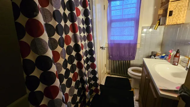 a bathroom with a sink a toilet and shower curtain