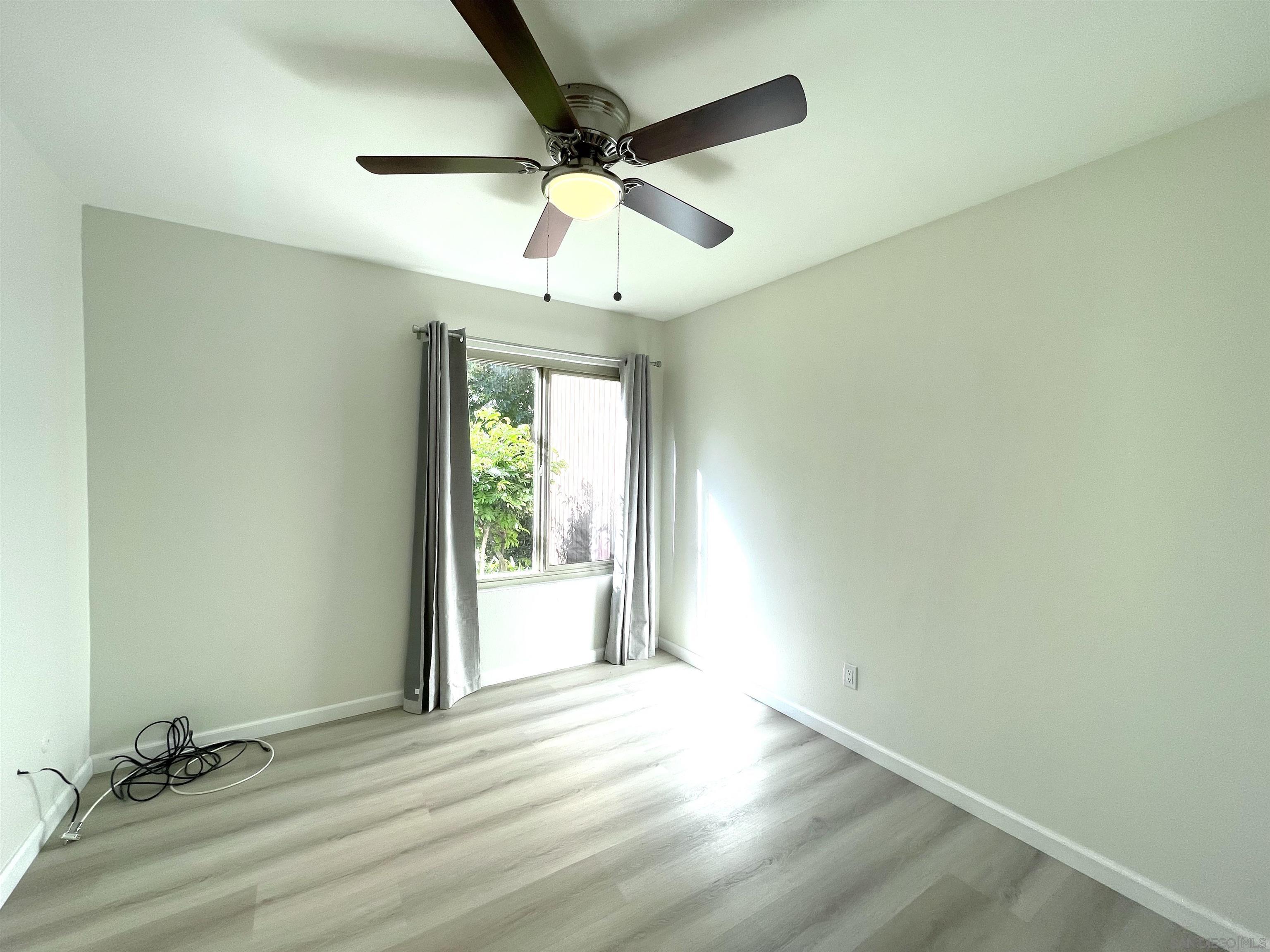 5938 Rancho Mission Road, Unit 129 San Diego, CA 92108 - Photo 11 of 29 an empty room with a ceiling fan and a window