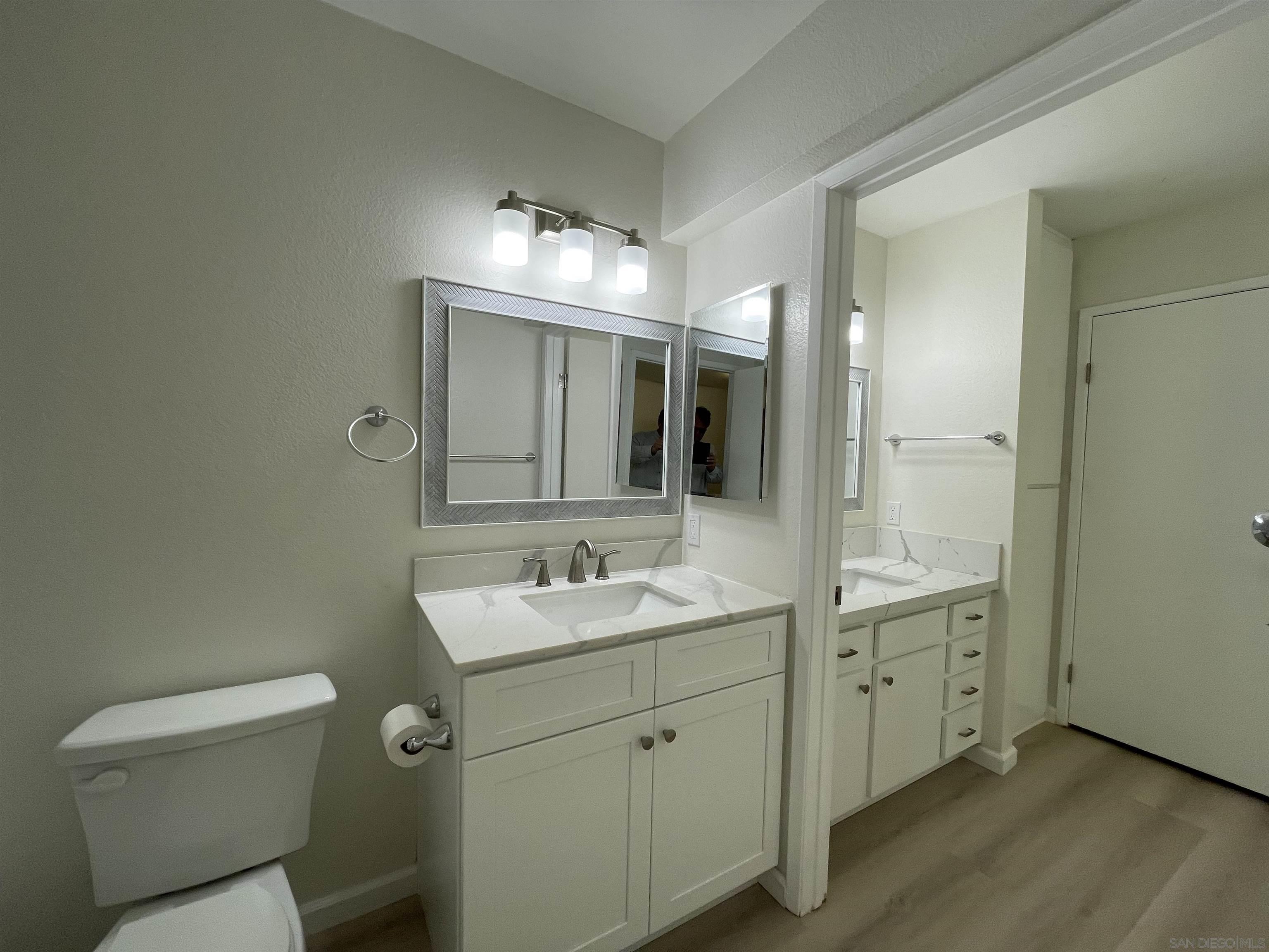 5938 Rancho Mission Road, Unit 129 San Diego, CA 92108 - Photo 14 of 29 a bathroom with a toilet sink and mirror