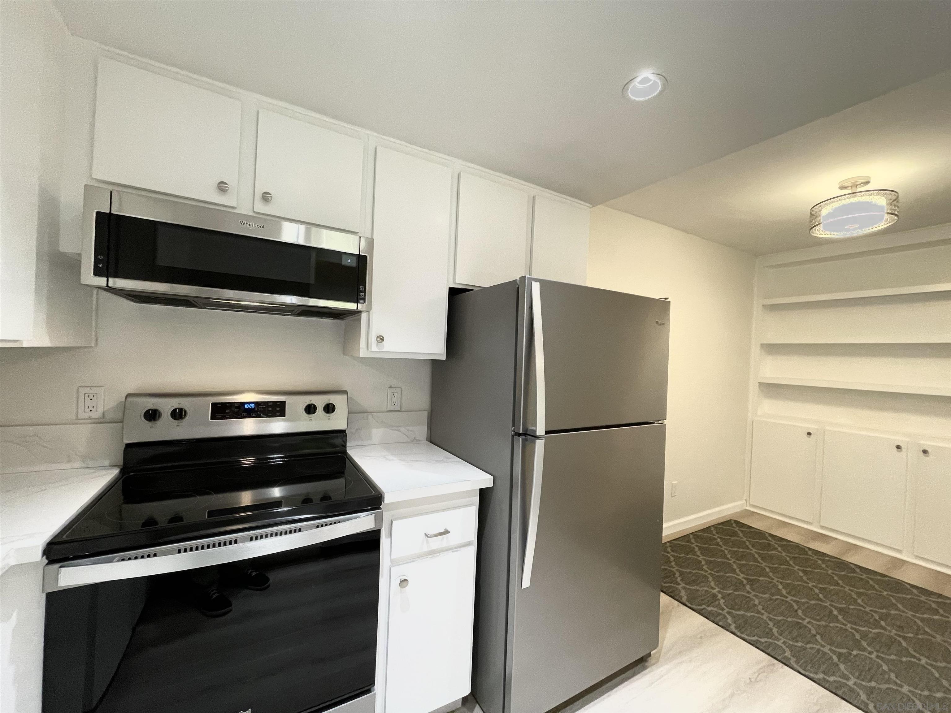 5938 Rancho Mission Road, Unit 129 San Diego, CA 92108 - Photo 17 of 29 a kitchen with a refrigerator stove and cabinets