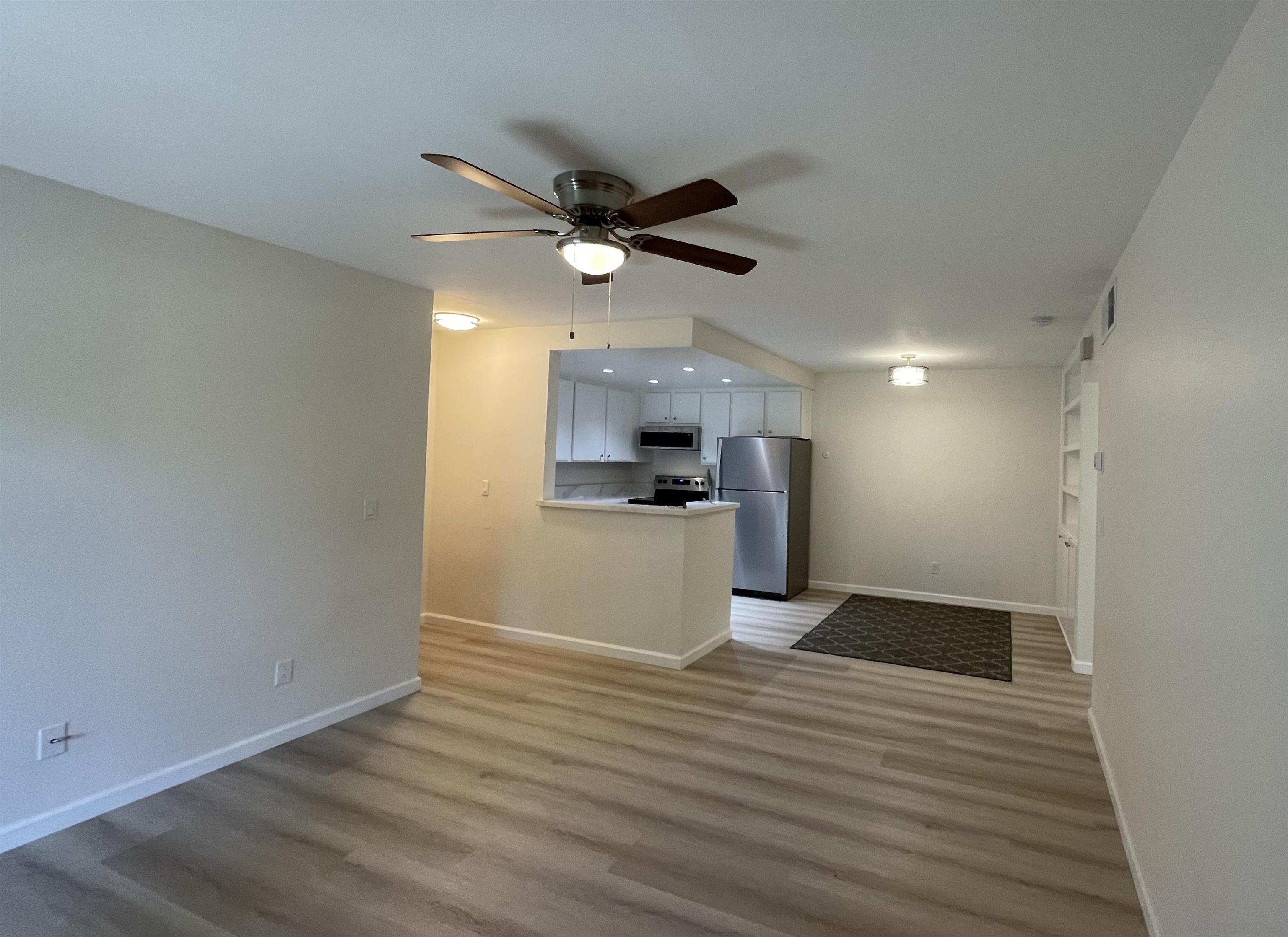 5938 Rancho Mission Road, Unit 129 San Diego, CA 92108 - Photo 28 of 29 a view of a kitchen with a dishwasher and wooden floor