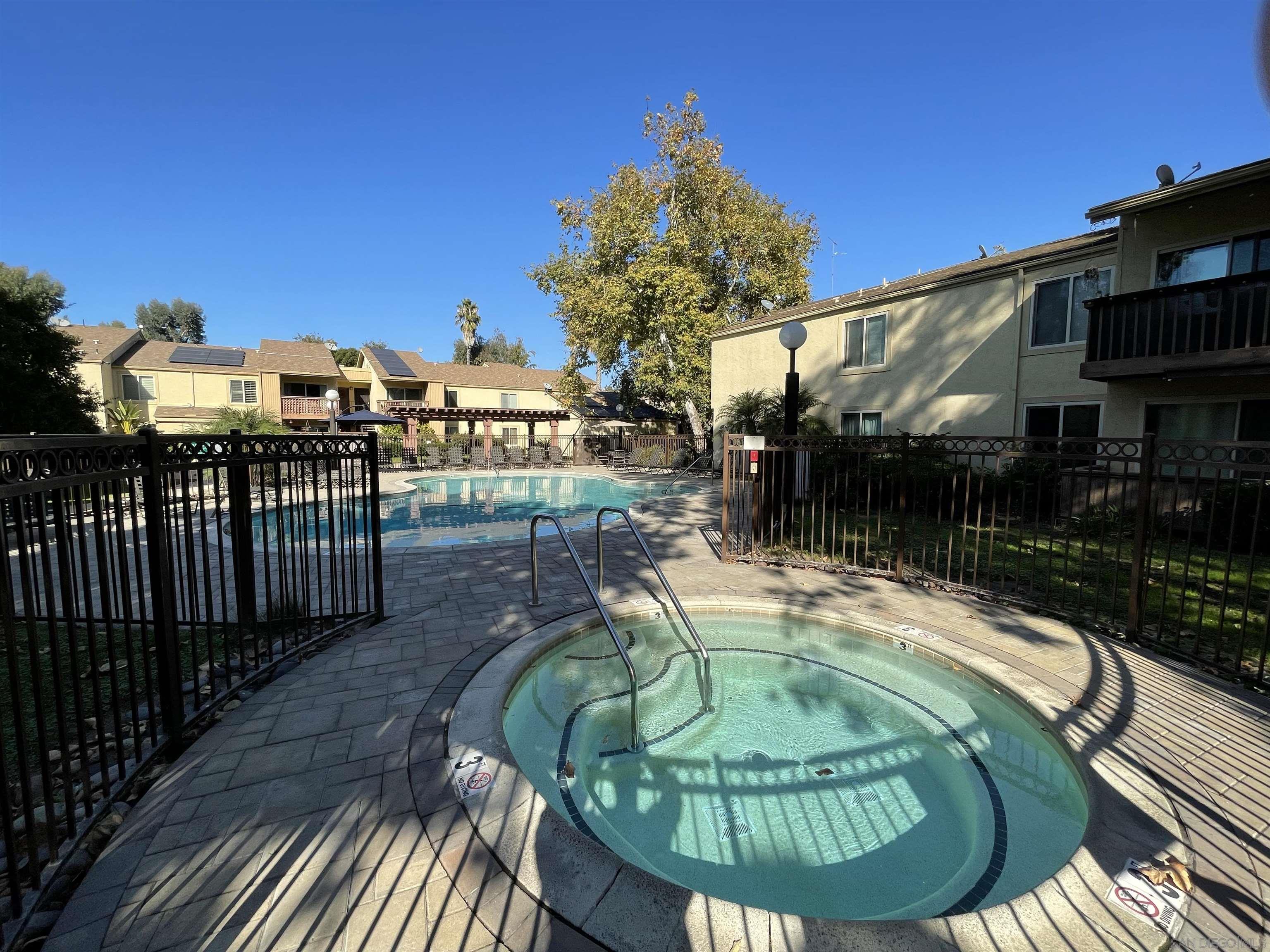 5938 Rancho Mission Road, Unit 129 San Diego, CA 92108 - Photo 4 of 29 a swimming pool with outdoor seating and plants