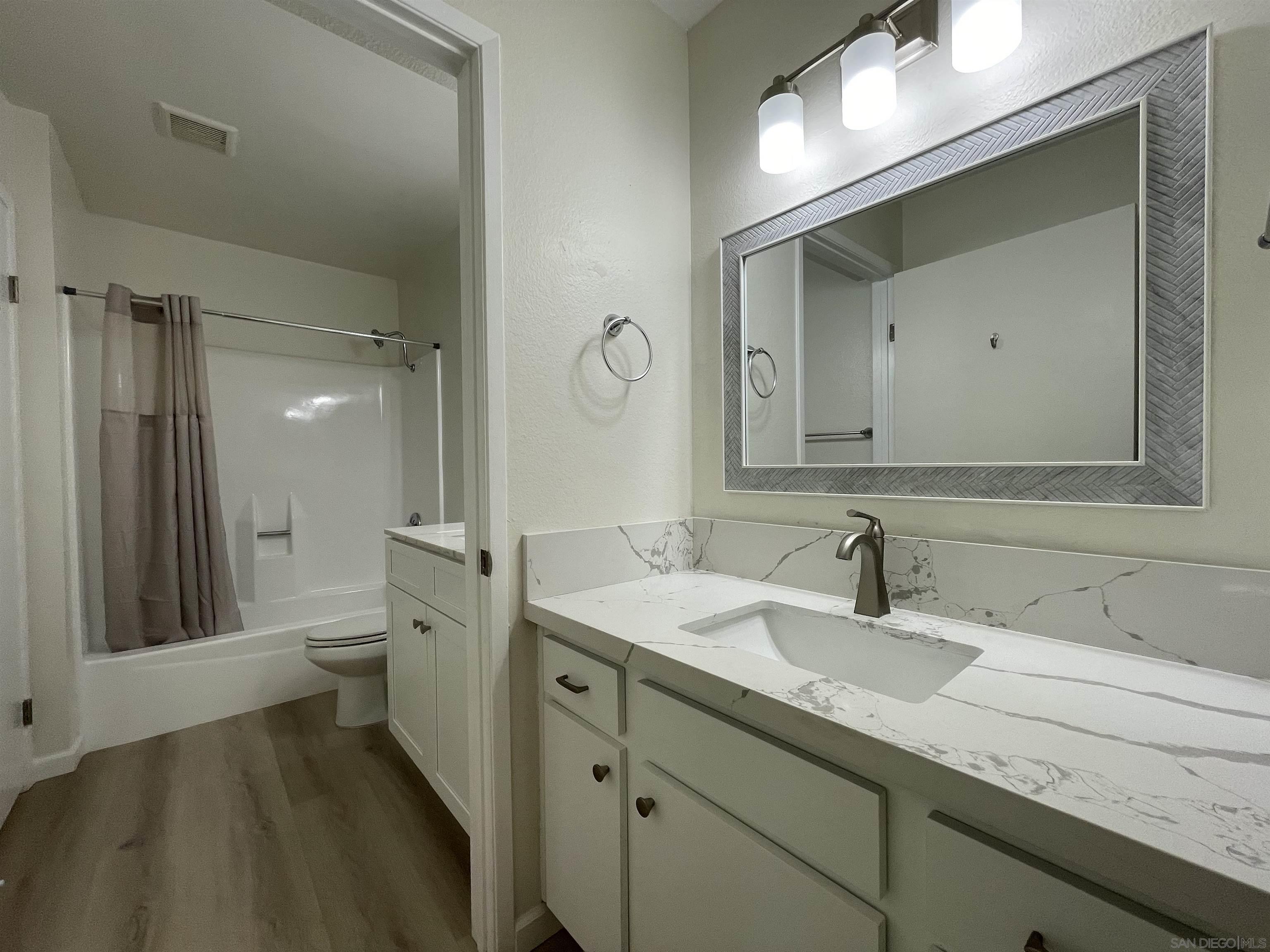 5938 Rancho Mission Road, Unit 129 San Diego, CA 92108 - Photo 7 of 29 a bathroom with a sink a toilet and a mirror