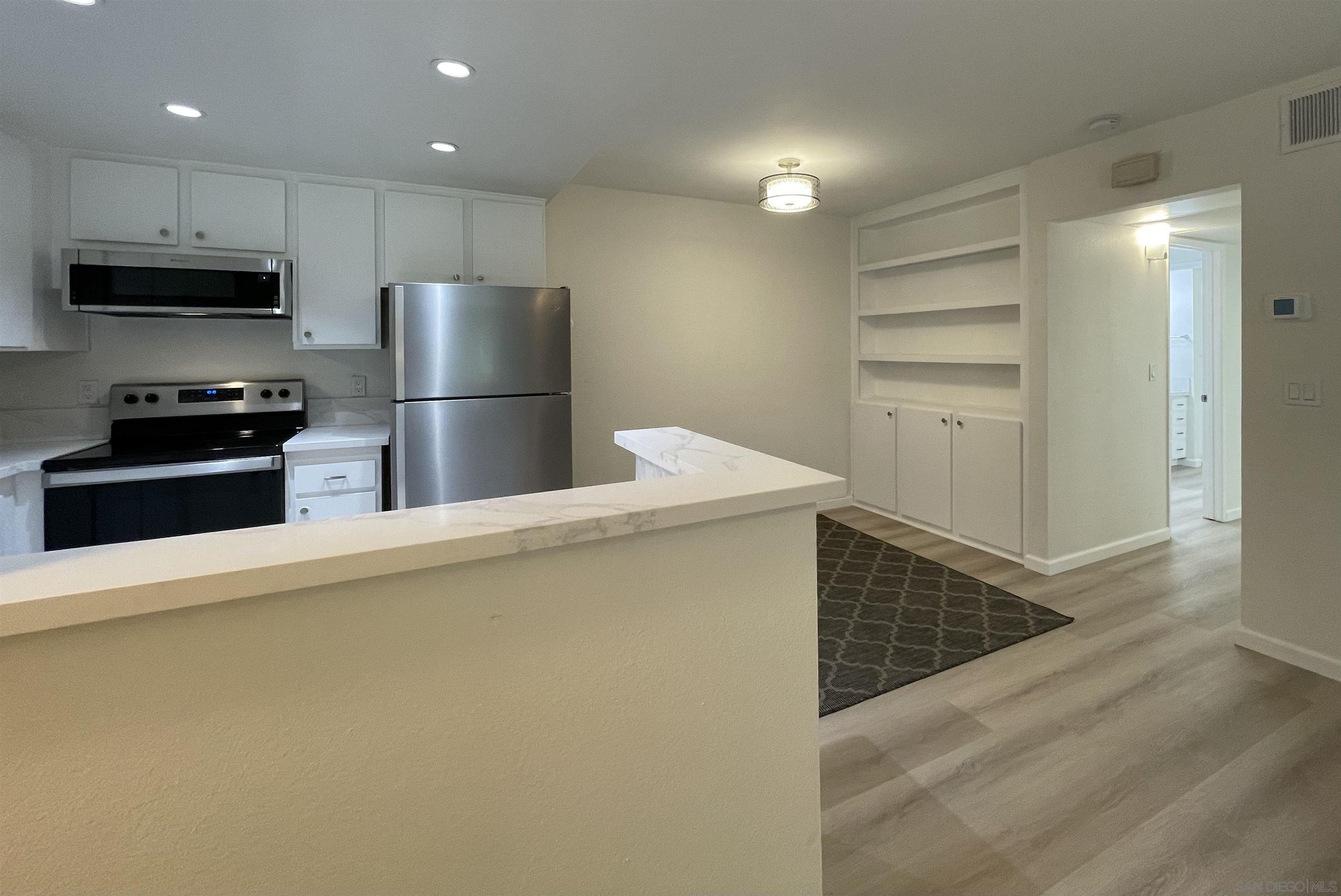 5938 Rancho Mission Road, Unit 129 San Diego, CA 92108 - Photo 10 of 29 a kitchen with stainless steel appliances a refrigerator and a stove