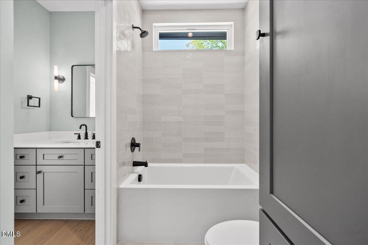 541 Bragg Street Raleigh, NC 27601 - Photo 35 of 44 a bathroom with a tub shower sink and vanity