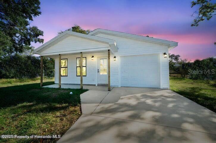 9002 Nakoma Way Weeki Wachee, FL 34613 - Photo 1 of 15 a front view of a house with garden