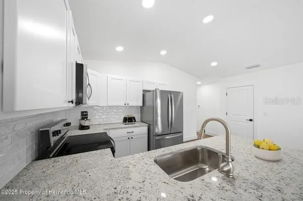 a kitchen that has a sink and a stove in it