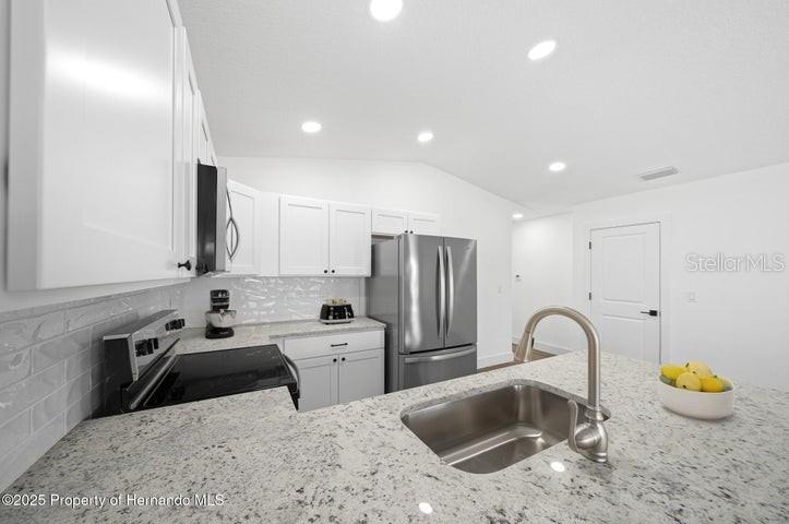 9002 Nakoma Way Weeki Wachee, FL 34613 - Photo 5 of 15 a kitchen that has a sink and a stove in it