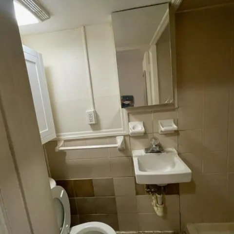 a bathroom with a sink a toilet and mirror