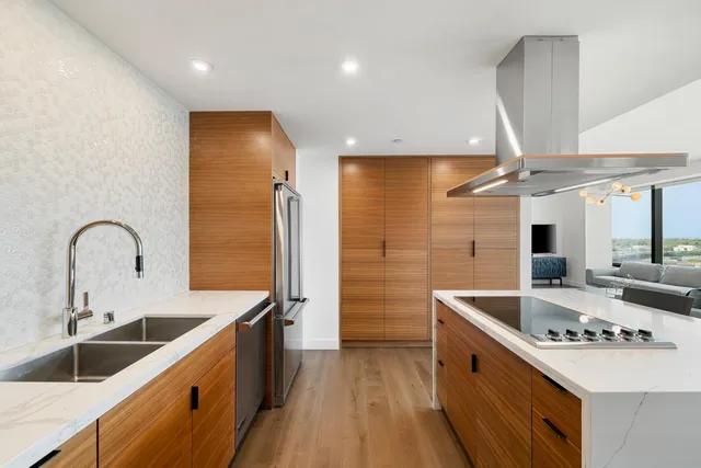a kitchen with stainless steel appliances kitchen island granite countertop a stove and a refrigerator