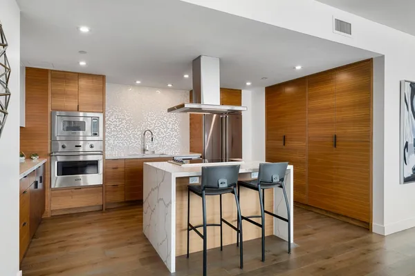 a bathroom with a granite countertop sink a mirror a glass door shower and a mirror
