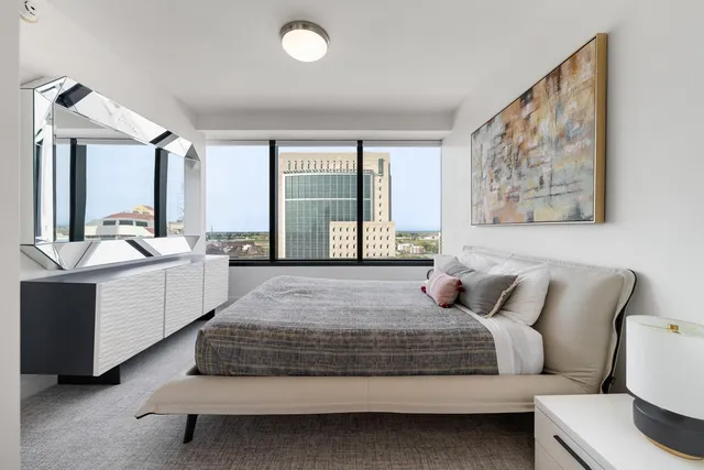 a spacious bedroom with a bed and a large window