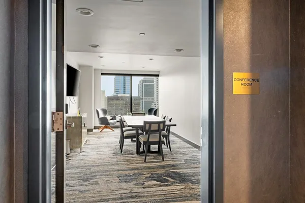 a dining hall with stainless steel appliances granite countertop a table chairs and a wooden floor