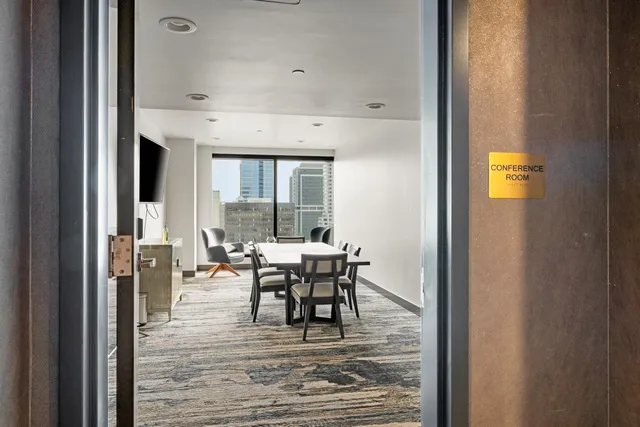 a dining hall with stainless steel appliances granite countertop a table chairs and a wooden floor