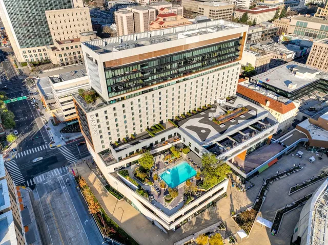 a living room with furniture and a large mirror next to a window