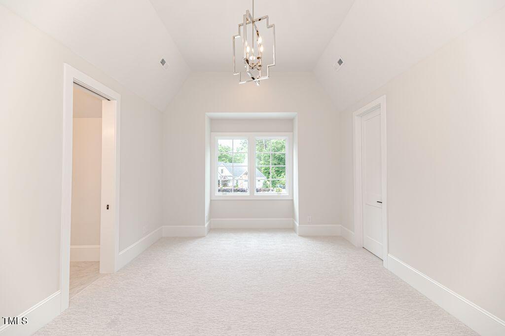 2101 Gresham Lake Road Raleigh, NC 27615 - Photo 37 of 48 an empty room with windows and chandelier