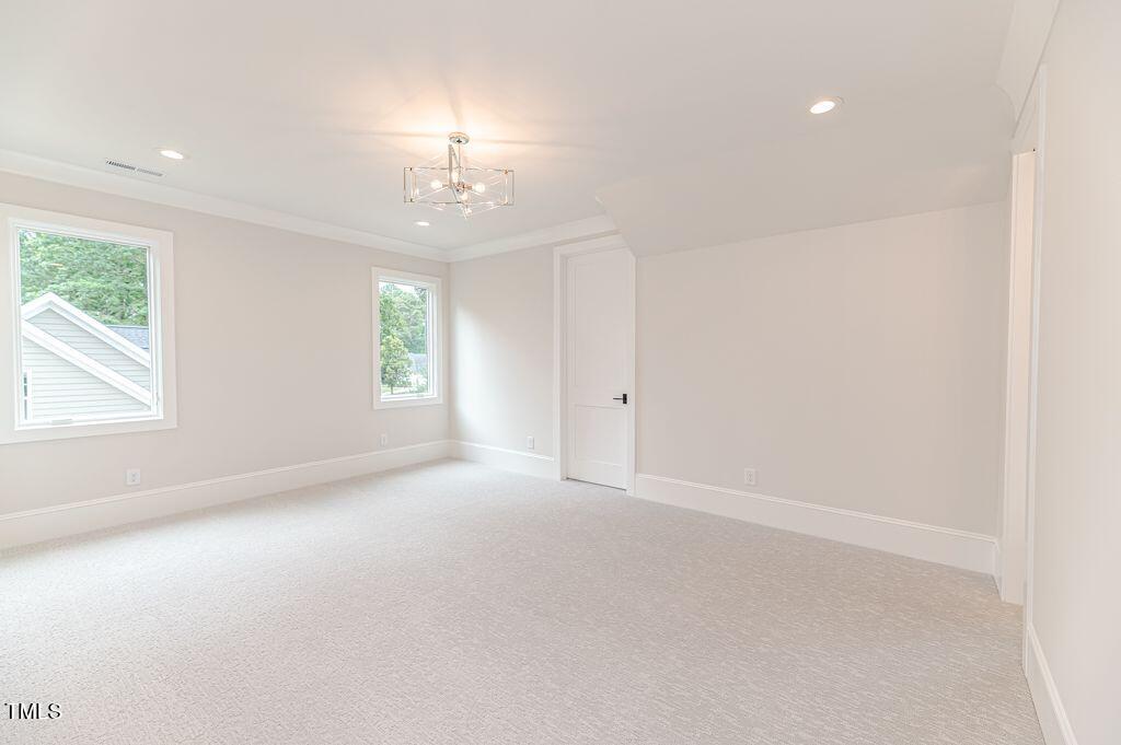 2101 Gresham Lake Road Raleigh, NC 27615 - Photo 41 of 48 en empty room with windows and chandelier