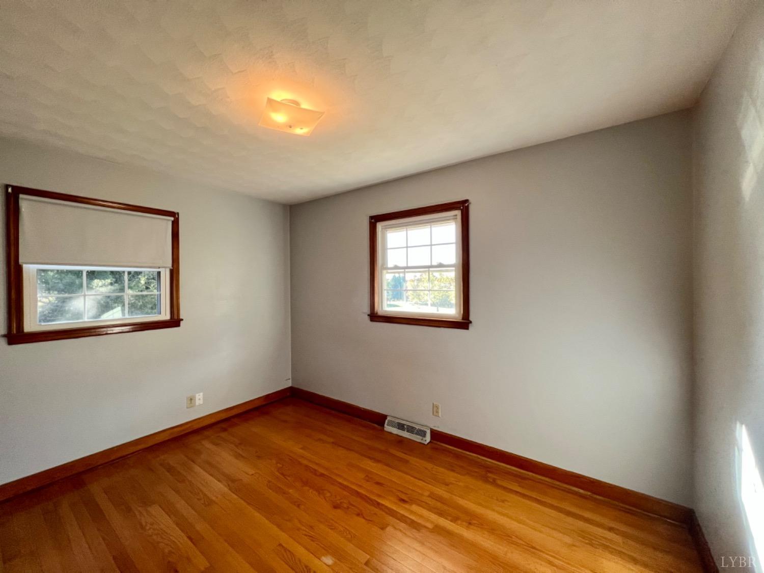 417 Jasper Wood Road Hurt, VA 24563 - Photo 10 of 36 a view of an empty room with wooden floor and a window