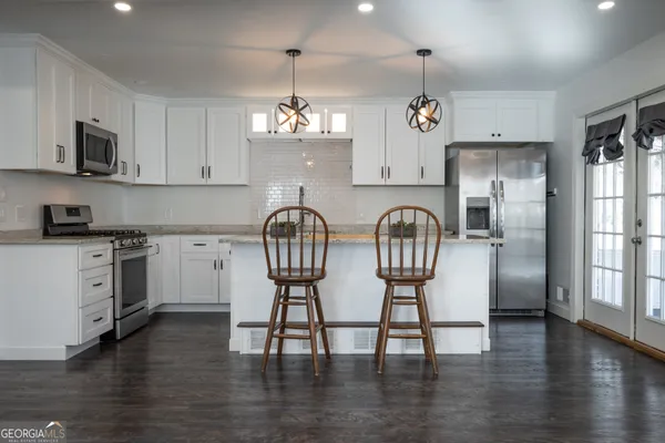 a kitchen with stainless steel appliances granite countertop white cabinets a sink and dishwasher