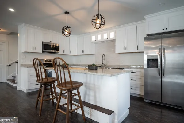a bedroom with a large bed chandelier and a window