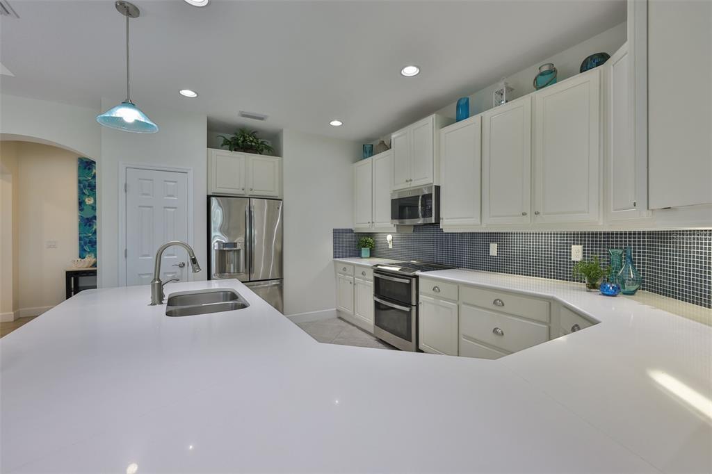 964 Pembroke Point Way Sun City Center, FL 33573 - Photo 18 of 66 a kitchen with stainless steel appliances granite countertop a refrigerator sink and cabinets