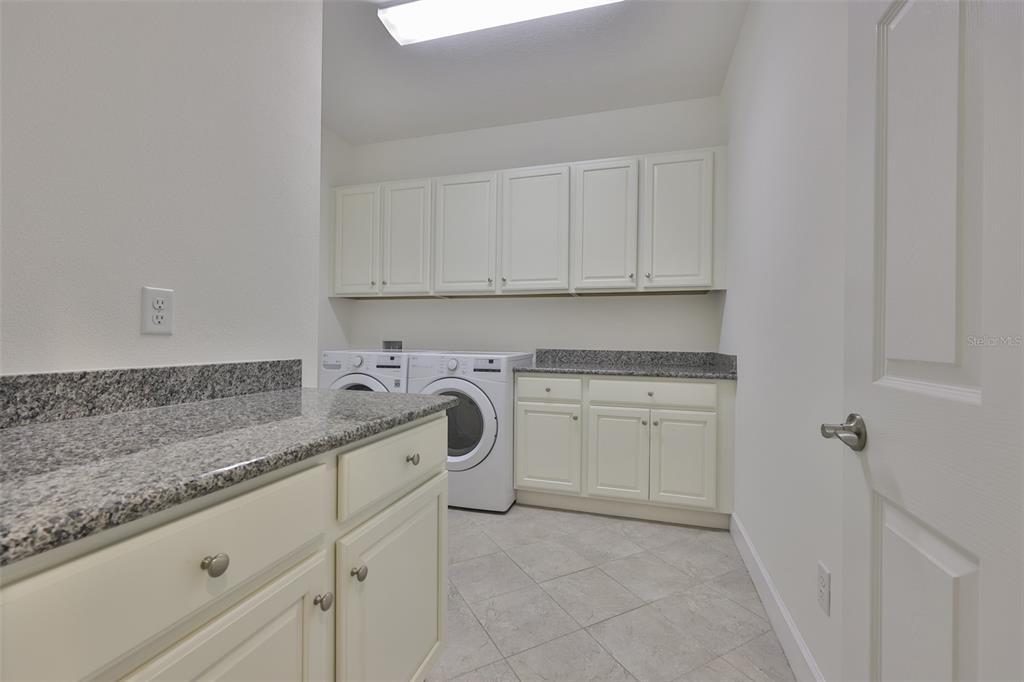 964 Pembroke Point Way Sun City Center, FL 33573 - Photo 25 of 66 a kitchen with white cabinets and white appliances