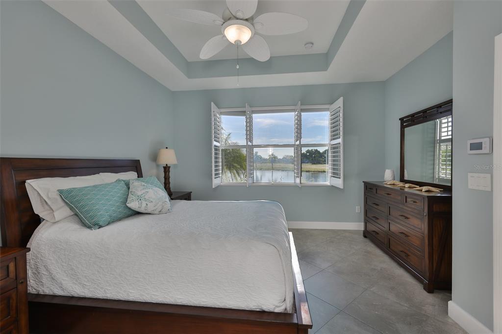964 Pembroke Point Way Sun City Center, FL 33573 - Photo 29 of 66 a bedroom with a large bed and a chandelier