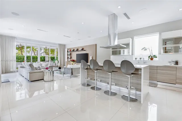 a living room with furniture kitchen view and a large window