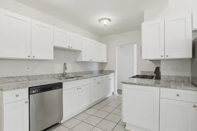 a kitchen with granite countertop white cabinets white stainless steel appliances with a sink and dishwasher