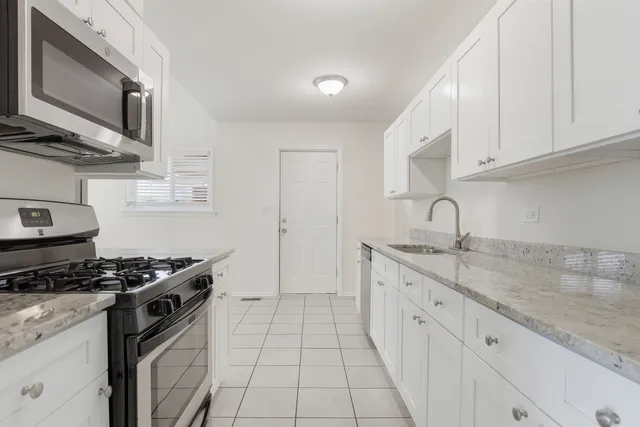 a kitchen with stainless steel appliances granite countertop a sink stove top oven and cabinets