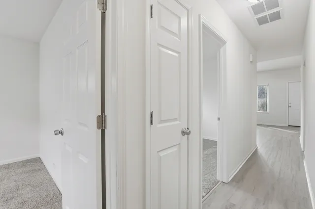 a view of a hallway with wooden floor