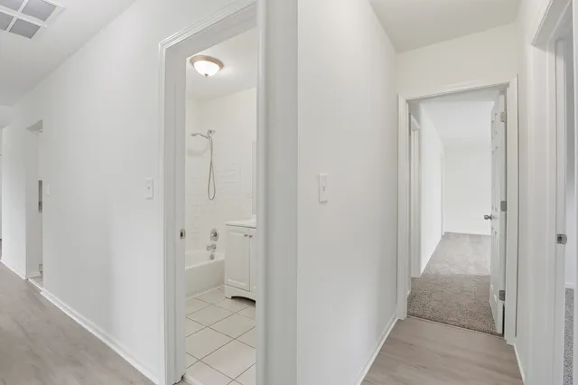 wooden floor with a bathroom view