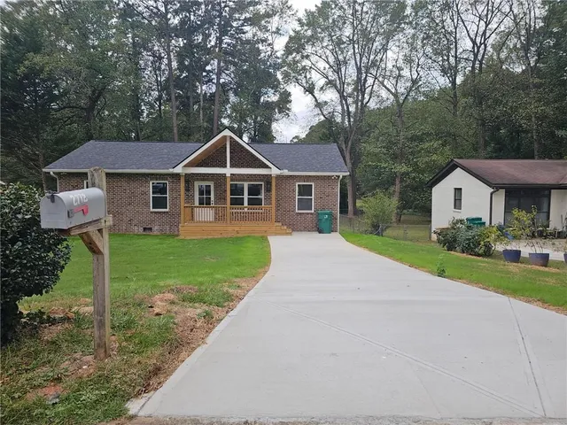 a front view of a house with a yard and trees