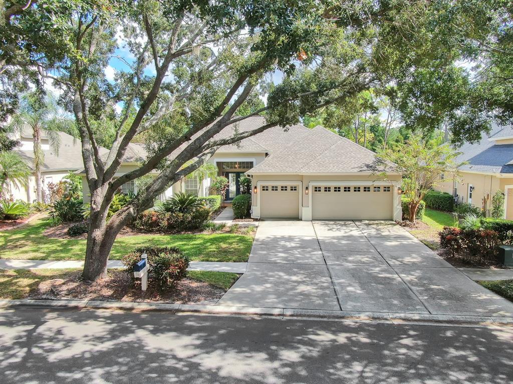 a front view of a house with a yard and trees