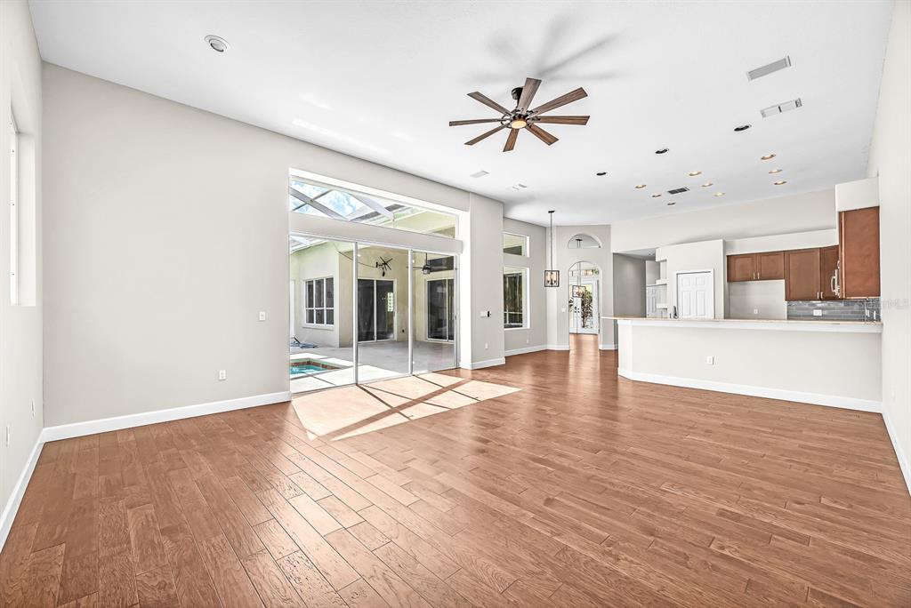 3504 Old Course Lane Valrico, FL 33596 - Photo 16 of 59 a view of an empty room with wooden floor and a kitchen