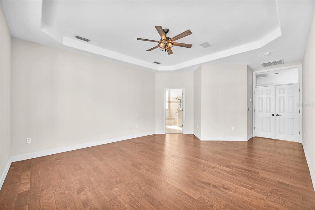 3504 Old Course Lane Valrico, FL 33596 - Photo 19 of 59 a view of an empty room with wooden floor and a ceiling fan