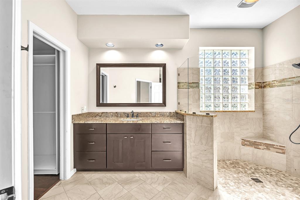 3504 Old Course Lane Valrico, FL 33596 - Photo 20 of 59 a bathroom with a granite countertop sink a mirror and a bathtub