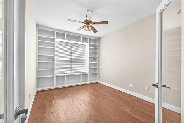 a view of a room with a ceiling fan and a window
