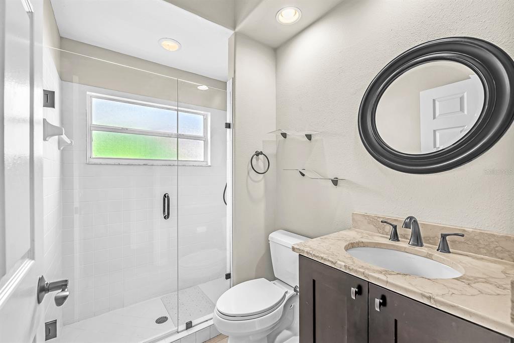 3504 Old Course Lane Valrico, FL 33596 - Photo 27 of 59 a bathroom with a granite countertop toilet a sink and a mirror