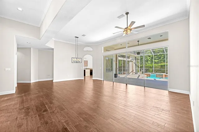 a view of an empty room with window and wooden floor