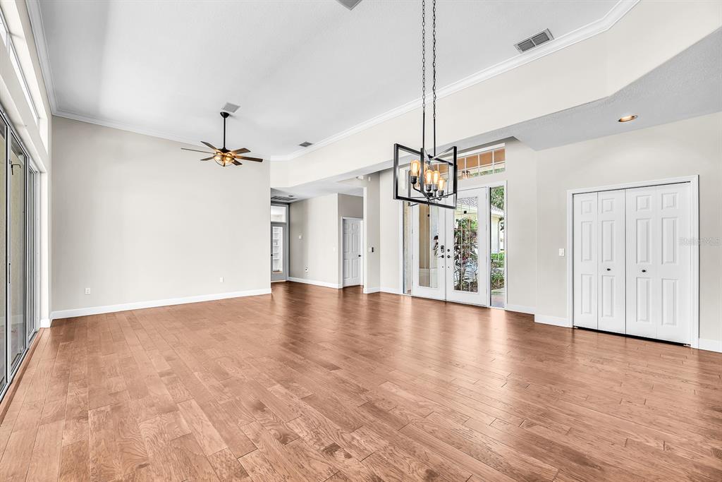 3504 Old Course Lane Valrico, FL 33596 - Photo 9 of 59 a view of an empty room with wooden floor ceiling fan and windows