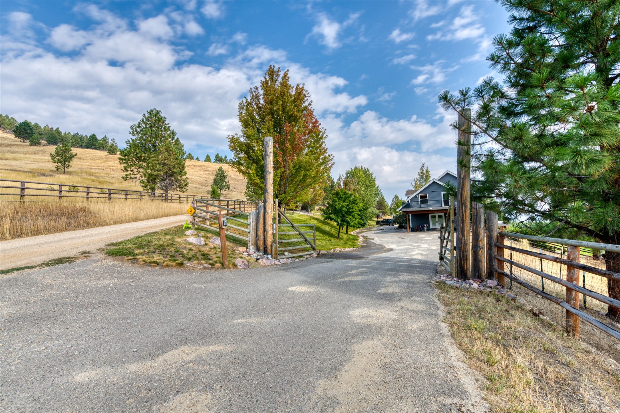 16374 Folsom Road Florence, MT 59833 - Photo 14 of 98 View of asphalt driveway featuring a gated entry and a view of rural / pastoral area