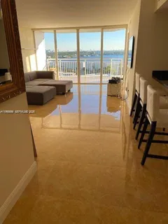 a living room with furniture and a floor to ceiling window