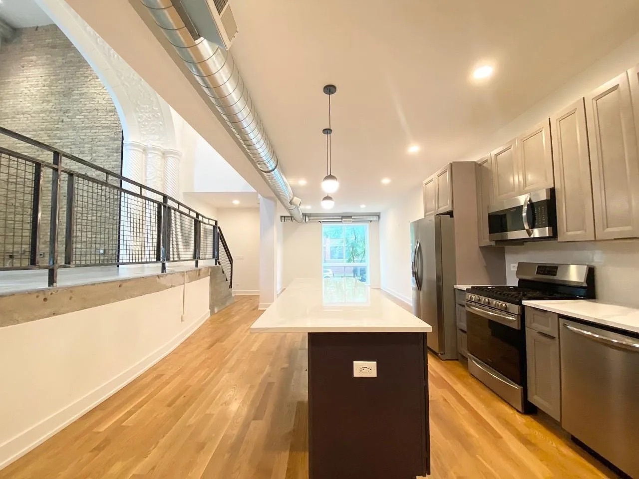 Undisclosed Address Chicago, IL 60640 - Photo 8 of 16 a large kitchen with stainless steel appliances kitchen island granite countertop a refrigerator a sink dishwasher a stove and white cabinets with wooden floor
